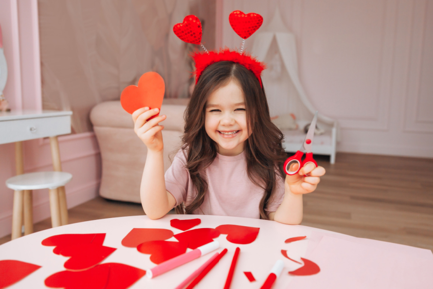 Child creating Valentine hearts